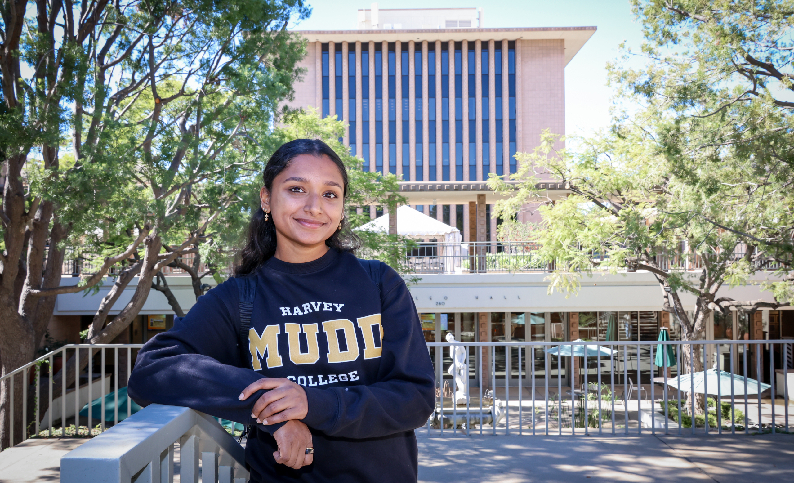 Student wearing harvey mudd collegiate sweater outside on hmc campus